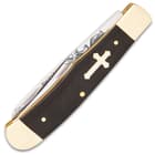 Classic Cross Trapper Pocket Knife has a nickel silver classic style cross inlaid into the black buffalo horn handle and the scales are secured by stainless steel pins