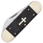 It has sleek and smooth black bone handle scales, which features an inlaid nickel-silver cross and brass pins