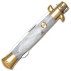 The knife’s mother of pearl handle is accented by brass-plated pins, bolsters, and shield.