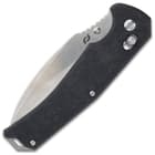 The pocket knife has carbon fiber handle scales with the locking button is on the side.