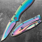 This knife has an all-over anodized rainbow finish with “Timber Wolf” printed on the pocket clip.