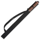 The sword is shown secured into a durable black nylon sheath with a shoulder strap.