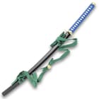 The black scabbard has a dark green hanging cord. 