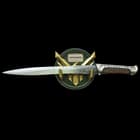 Green and gold display wall mount featuring the hawk sigil of House Atreides with the knife resting on gold prongs. 
