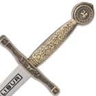 The 6 1/4” overall replica letter opener has an intricately designed metal alloy handle with a gold-toned finish