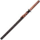 The 40 1/10” katana slides into a black lacquered wooden scabbard with gold splatter-paint accents and brown cord-wrap
