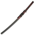 The 41” overall katana slides securely into a black lacquered wooden scabbard, which has a red splatter-paint accent