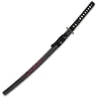 Samurai sword shown inside the glossy black scabbard with red dragon design and black hanging cord. 