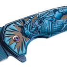 A detailed view of the shogun warrior with skull face design on the side of the blue knife handle.