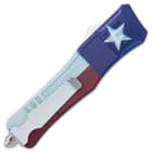 The black aluminum handle has crosshatching to make it grippy and it features the Texas flag and a glassbreaker pommel