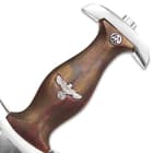 The hardwood handle fits the cross guard well and it features a SA runes button and a “high-necked” grip eagle