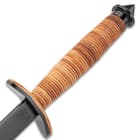 The knife’s handle is made of stacked leather with cast thumb notches.