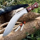 Gurkha Kukri with its curved blade and hardwood handle shown alongside two smaller knives and black leather sheath.