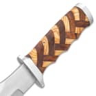 Detailed view of the walnut and olive wood handle with basket weave pattern and stainless steel handguard and pommel.