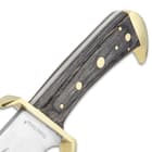 Detailed view of the classic gray hardwood handle with brass pins and brass-plated guard.