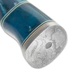 The ridged handle is crafted of blue dyed bone, accented with brass and black spacers, and the flat pommel is Damascus