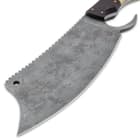 It has a 7 1/2” blued carbon steel, cleaver blade that’s 2 3/4” wide and has a toothy spine, plus, an aggressive finger choil