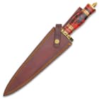 The knife has a keenly sharp, 9” Damascus steel dagger blade, which extends from a brass fileworked guard