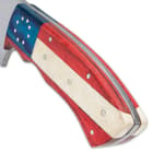 The handle scales are crafted in red and blue wood and white bone in a patriotic design, secured with stainless steel pins