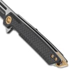 The slimline black handle scales are crafted of G10 and carbon fiber, secured with brass screws, and feature a lanyard slot