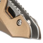 The metallic tan, aluminum handle scales are secured with screws and have a sleek, futuristic look