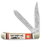 The trapper has two sharp 440 stainless steel blades, which feature Pearl Harbor themed etchings, including newspaper headline, “War! Oahu Bombed By Japanese Planes”