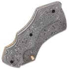 The grooved handle scales are crafted of Damascus steel and the handle features fileworked brass liners