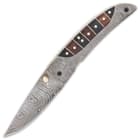 The knife has a razor-sharp, 3” Damascus steel blade, which can be deployed with a brass thumbstud