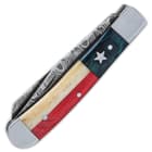 It has Texas Flag themed handle scales in red and blue wood and white bone with a stainless steel inset star and pins