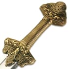 Zoomed view of brass handle and pommel with intricate medieval viking designs

