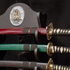 Three swords sit in the 16 black wood sword display with the cast resin samurai medallion at the top in view. 
