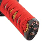 The hardwood handle is traditionally wrapped in genuine ray skin and red cord and has a matching, decorative pommel