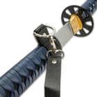 It has a 28 3/4” high carbon steel blade, which extends from a dark, black metal alloy tsuba and a brass habaki