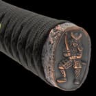 The cast metal, alloy pommel has an intricate embossed Samurai warrior design and the habaki is solid, polished brass