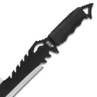 The sword’s blade has jagged cutouts at the top of the blade, just beneath the black cord wrapped handle. 