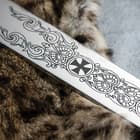 The 36” stainless steel blade has medieval etchings on it. 