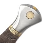 Zoomed view of the cast metal pommel with decorative brass-colored accents.