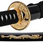 Detailed view of the gold dragon design of the scabbard and coordinating gold dragon design of the tsuba. 