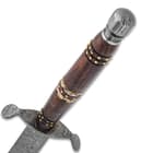 The handle is crafted of wood with brass accents
