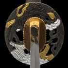 The hardwood handle is wrapped in genuine, white rayskin and black cord and the tsuba is metal alloy in a golden dragon design