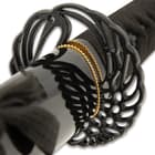 The black metal tsuba has an open, circular winged design and sits above a polished brass habaki