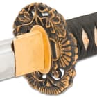 The handle is wrapped in genuine white ray skin and black cord-wrap and the intricate floral-themed handguard is solid brass with black accents