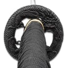 The black metal tsuba is in the shape of a dragon