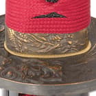 The brass tsuba has a dragon design just beneath the bright red cord wrap of the handle. 