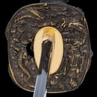 It has an antiqued brass, square tsuba with an intricately detailed Samurai and Chinese dragon design