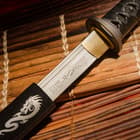 Katana sword encased in wooden dragan saya with peeking of steel blade showcasing laser etchings in Japanese characters
