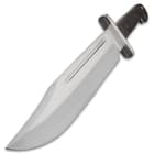 Angled view of a large silver bowie knife with a large thick steel handguard. 
