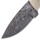 Its 3” Damascus steel blade is carefully honed to a razor-sharp edge and the drop point blade is perfect for skinning and carving
