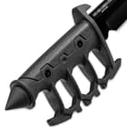 Detailed view of the knuckle knife’s handle, made of cast metal, with no-slip rubberized grip inserts and a skull crusher pommel.