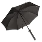 The black nylon umbrella opened and looks like a traditional umbrella. 
